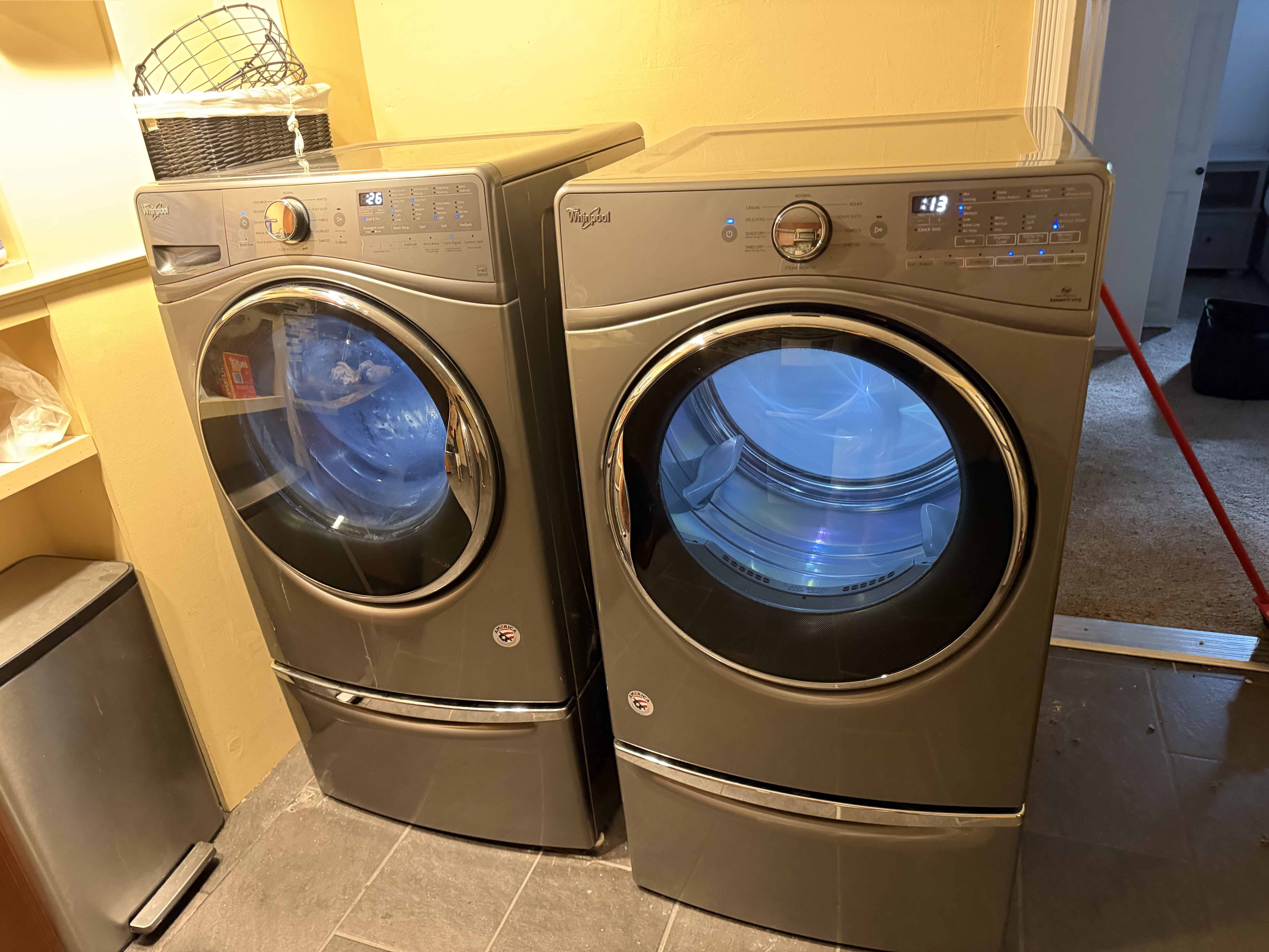 Whirlpool washer and dryer set standing side by side in a laundry room