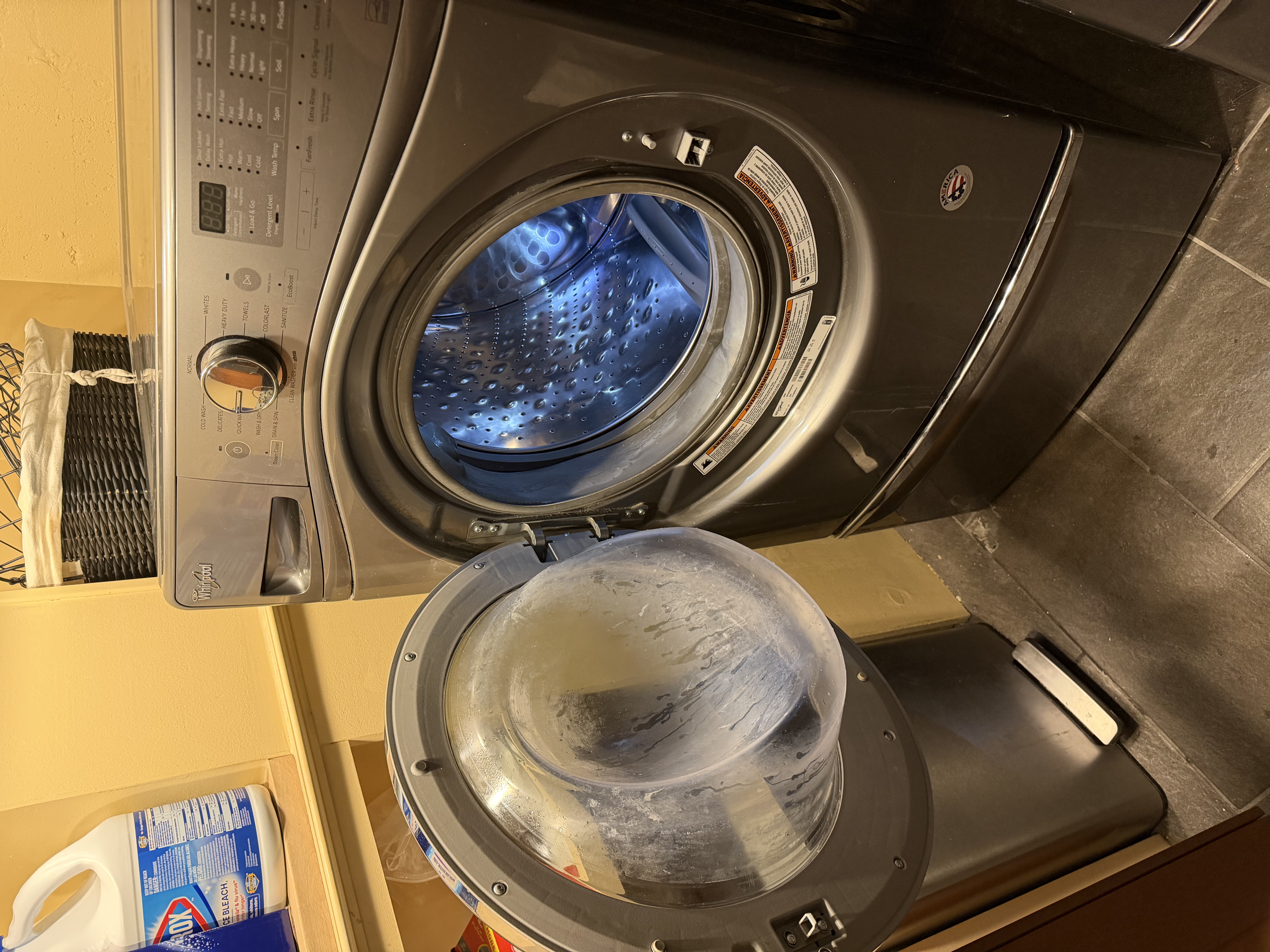 The washer with its door open showing the stainless steel drum
